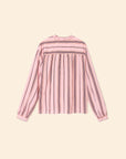 The Sabina Top by Xirena is a long-sleeved pink striped blouse with dark vertical and horizontal patterns, crafted from drapey viscose. It features a high neckline and buttoned cuffs, shown against a plain beige background.