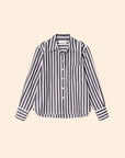 The Monroe Shirt by Xirena is a black and white vertically striped cotton button-front shirt with a collar, long sleeves, chest pocket, and buttoned cuffs, shown on a plain beige background.