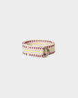 The Stevie Belt by Xirena features a coiled, vintage-inspired design with pastel stripes in pink, yellow, and beige, plus a silver-tone D ring buckle. Shown on a plain white background.