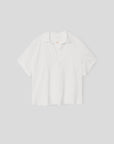 The Spencer Tee by Xirena is a relaxed-fit, plain white cotton polo with short sleeves and an open V-neck collar, made in Los Angeles and shown on a light gray background.