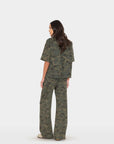 Xirena Renzo Sweatpant and matching top in neutral tones, shown from the back with beige shoes on a white background.