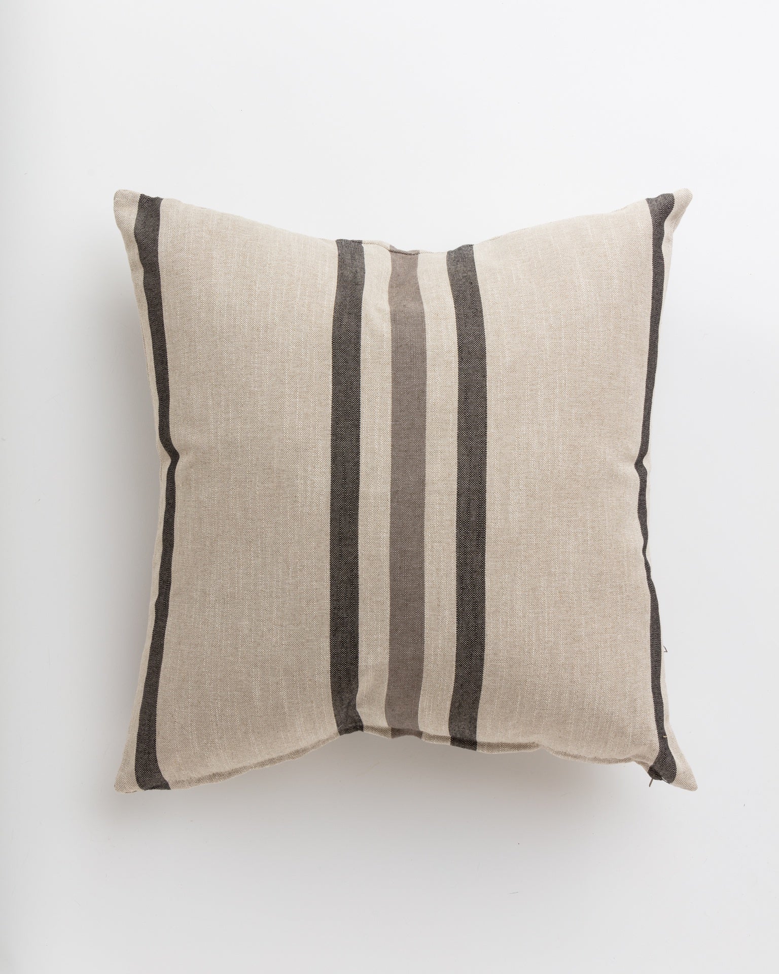 The Tri-Stripe Earth 24x24" pillow by Gabby, ideal for a cozy bungalow, is beige and square with three vertical dark grey and black stripes running down the center against a plain white background.