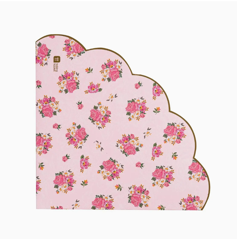 An intricately shaped notepad with a scalloped edge, featuring the Faire Scalloped Pink Floral Napkins 20PK, inspired by the bungalows of Scottsdale Arizona, against a pale pink background.
