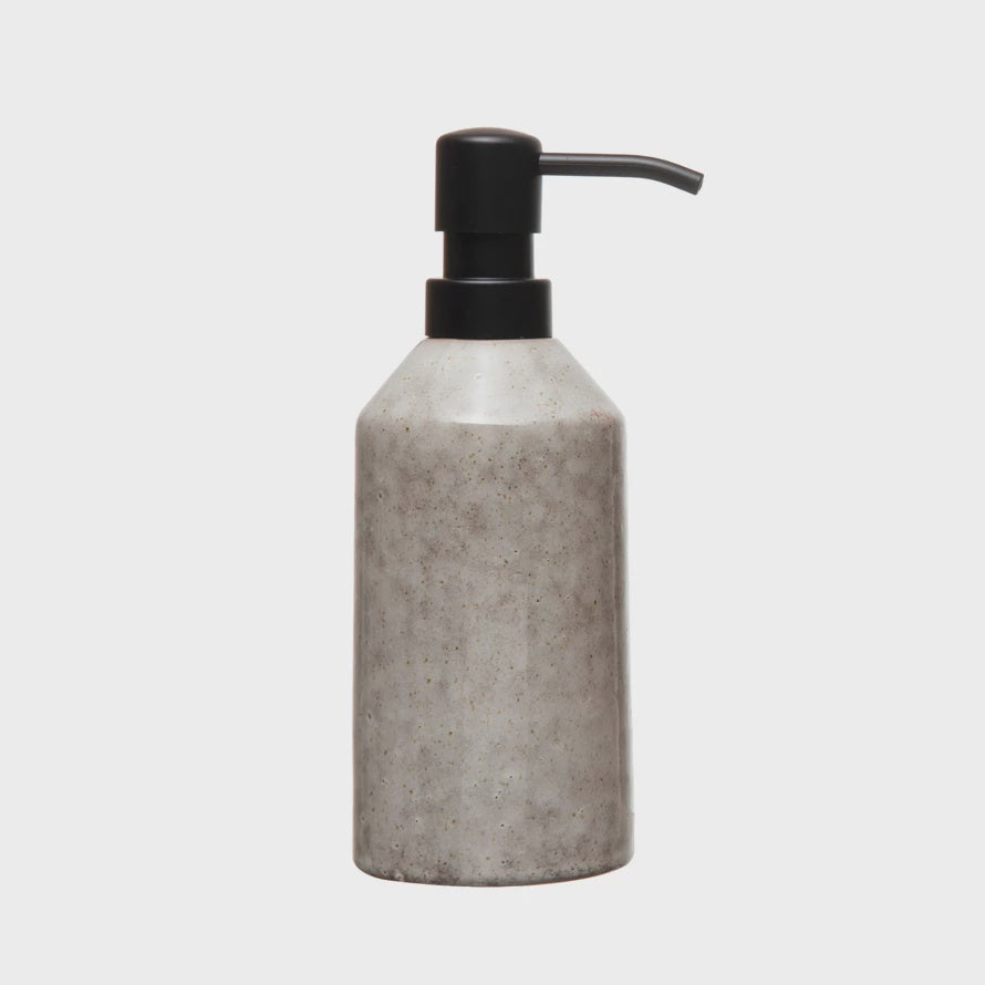 A stoneware soap dispenser from Bloomingville with a speckled gray finish and a black pump, isolated on a white background, reminiscent of Scottsdale Arizona aesthetics.