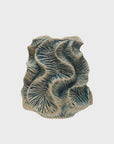 The Bloomingville Textured Vase features an irregular, wavy shape with dark blue, fern-like patterns on light beige stoneware. Handcrafted for unique charm, it makes a striking accent against a plain white backdrop.