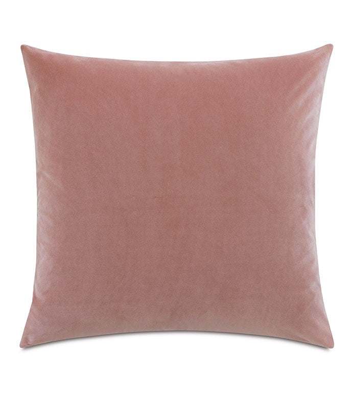 A soft, blush pink Alma Velvet 24x24" pillow from Eastern Accents displayed against a white background, showing a simple and smooth texture with a subtle sheen, perfect for a Scottsdale Arizona bungalow.