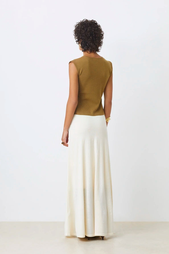 A person with short curly hair faces away, wearing the SUNCOO PAGNI S/L button front jumper in olive green and a long white skirt, set against a plain white background.
