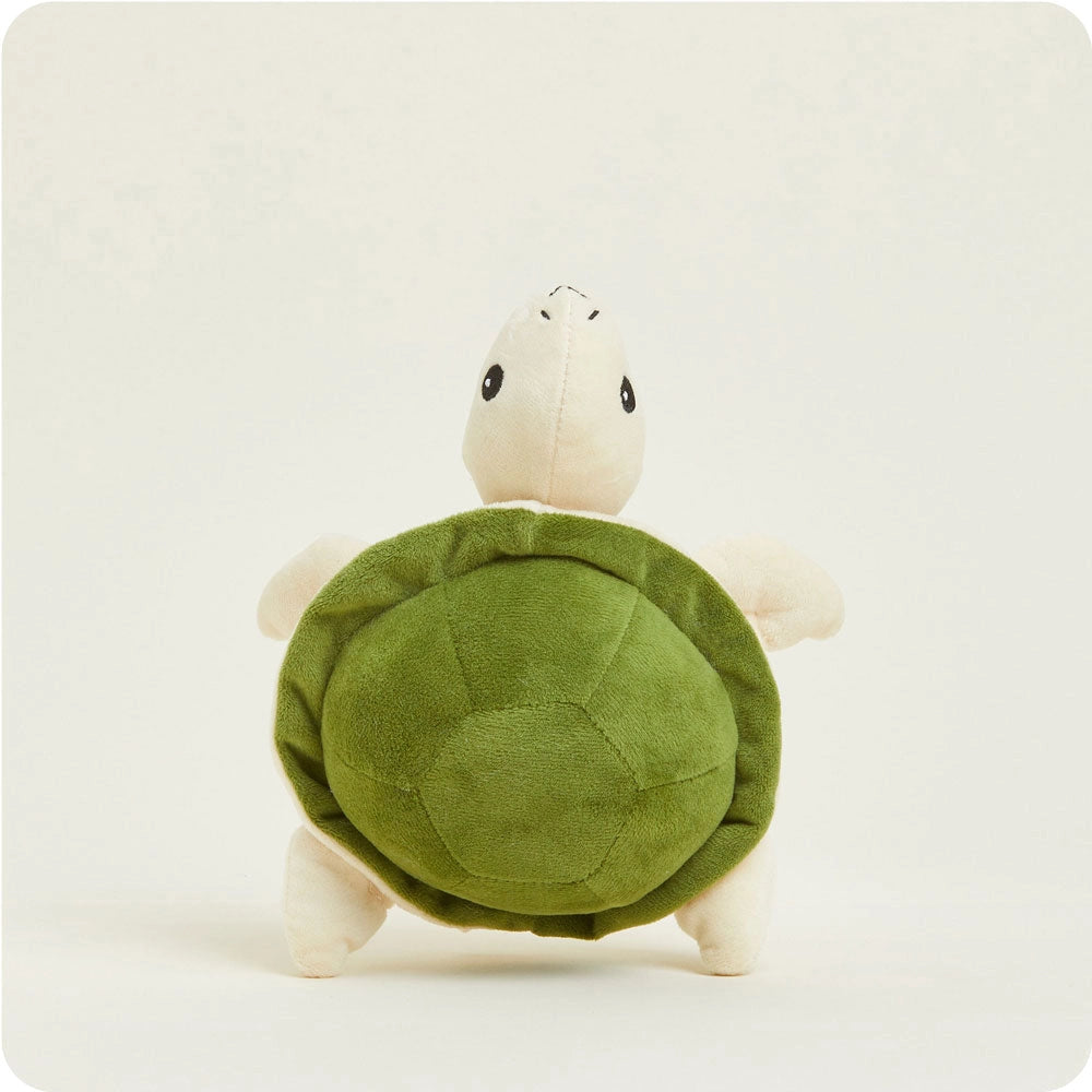 The Turtle Warmies Junior by Faire is a microwavable plush turtle with a green shell and beige limbs and head, shown standing upright against a plain light background.