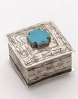 The Small Stamped Box w/ Turquoise Cross by J Alexander Rustic Silver features a raised turquoise cross and bold geometric designs—ideal for Southwestern décor. Photographed on a plain white background.