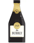 Illustration of a MME Napkin by Faire, featuring a festive champagne bottle with a black label adorned with a gold seal. The words "POP the BUBBLY" appear in bold letters, and the design is completed with stars and sparkles to enhance the celebratory theme.