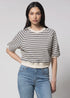 A woman with long dark hair wears the Perfectwhitetee French Terry SS Raglan Sweatshirt, a 100% cotton cream short-sleeve top with black stripes, paired with high-waisted light blue jeans. She stands against a plain light background, hand on hip.