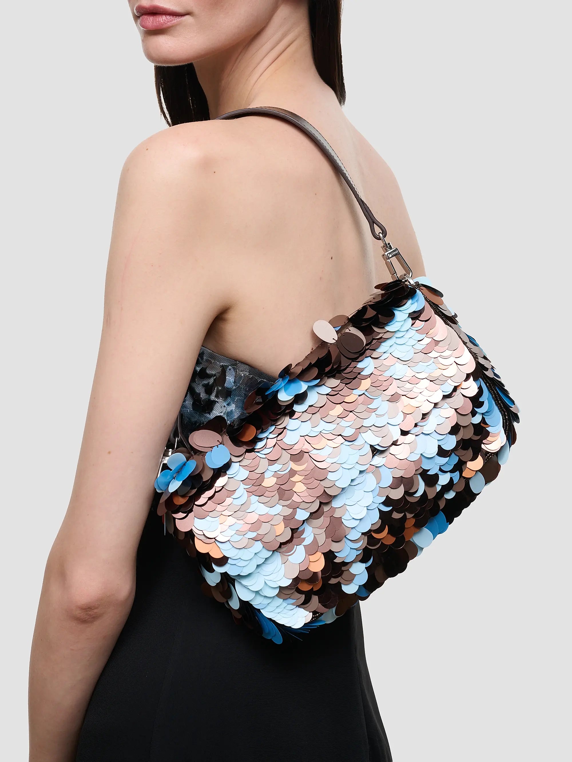Staud Timmy Convertible Shoulder Bag with embellished paillettes and leather strap, carried by woman with dark hair.