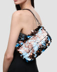 Staud Timmy Convertible Shoulder Bag with embellished paillettes and leather strap, carried by woman with dark hair.