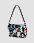 Black leather Staud Timmy Convertible Shoulder Bag with overlapping paillettes on a gray background.