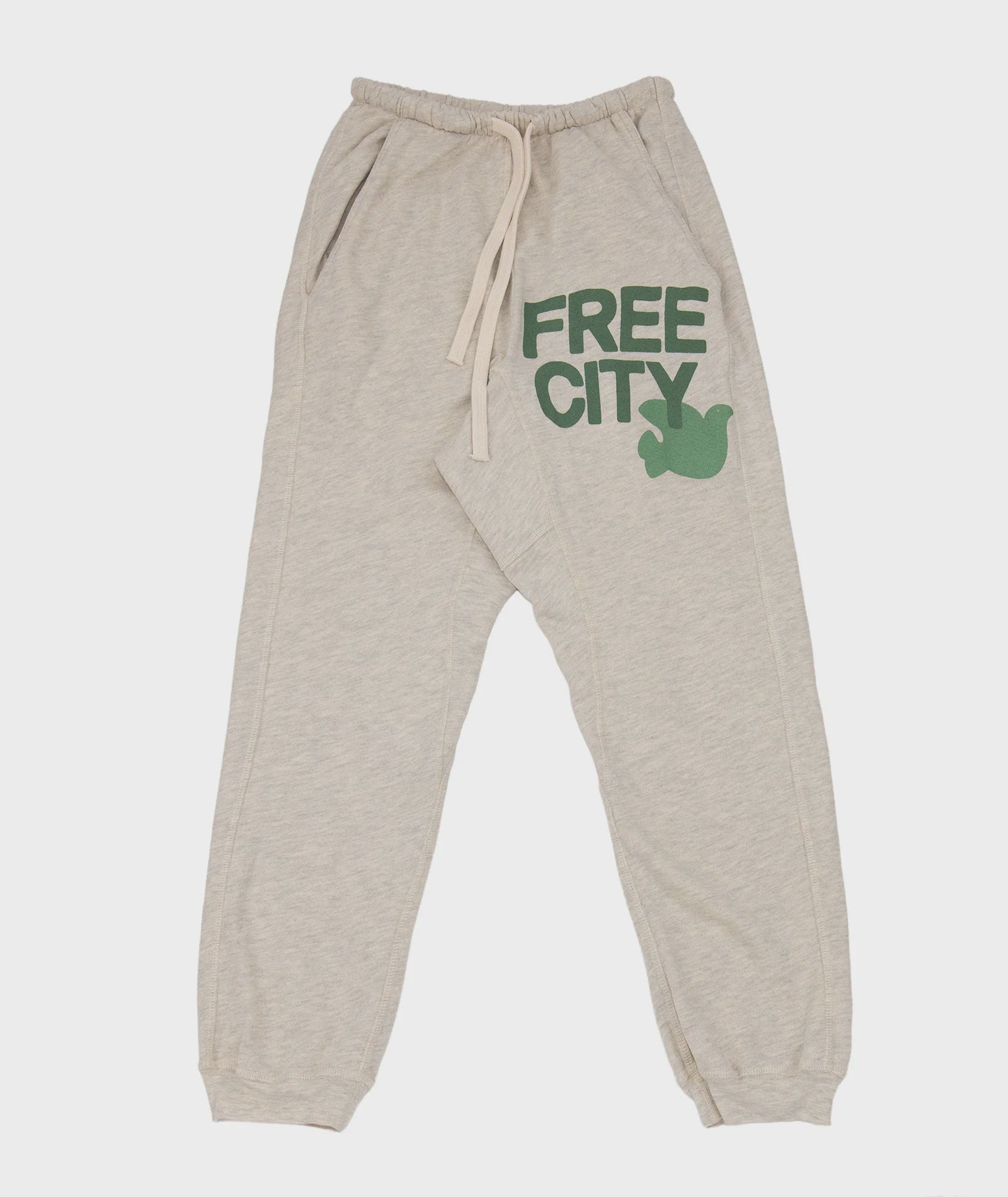 The Freecity Large Pocket Sweatpant by Free City (sparrow, LLC) features a beige drop crotch design with elastic waistband and cuffs, cream drawstring, and green "FREE CITY" text with bird graphic—an effortless style essential.