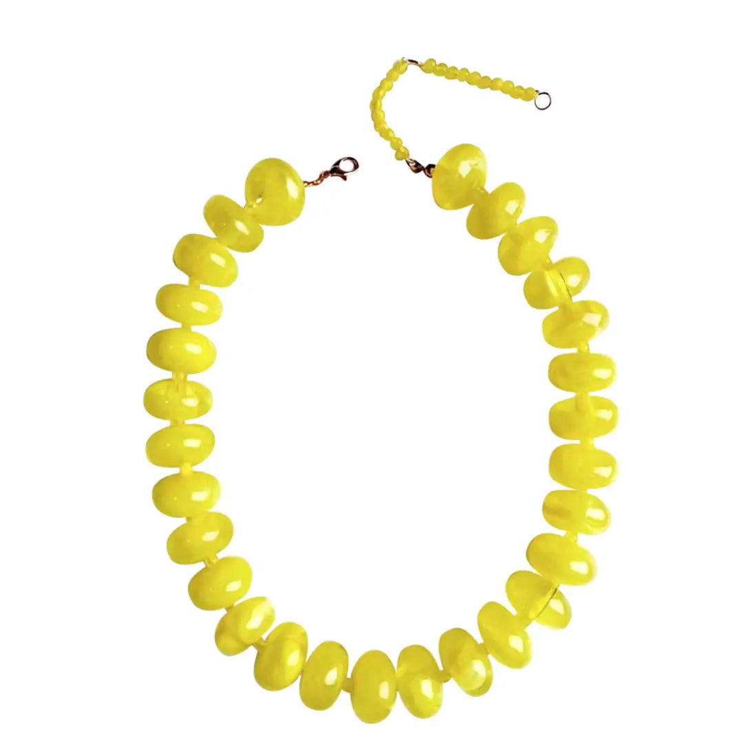 The Faire Bailey Chunky Beaded Necklace showcases large, glossy, bright yellow beads in graduated sizes, finished with a matching bead extension and metal clasp for a bold statement look.