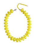 The Faire Bailey Chunky Beaded Necklace showcases large, glossy, bright yellow beads in graduated sizes, finished with a matching bead extension and metal clasp for a bold statement look.