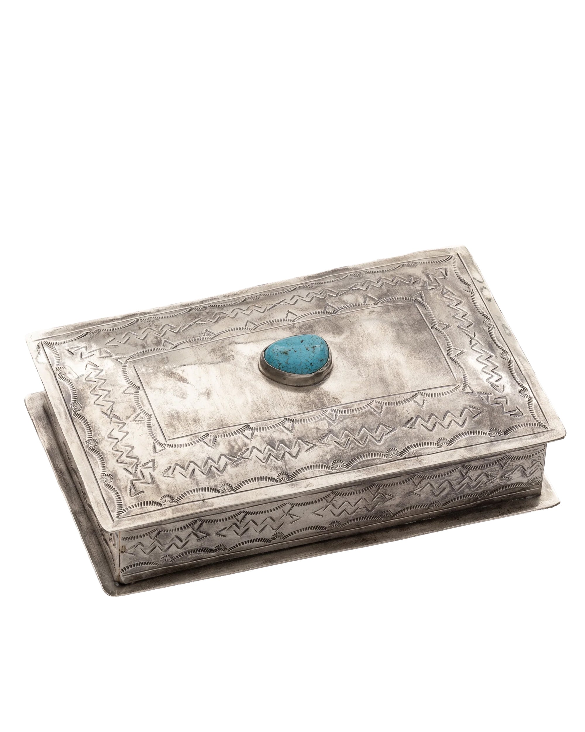 The J Alexander Rustic Silver 83-1-T Stamped Rec Box Turq is a handcrafted rectangular silver box with engraved patterns and an oval turquoise stone on the lid, ideal as a Southwestern-inspired decorative treasure box.