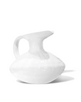 A white ceramic Pitcher No. 431 from Montes Doggett with a glossy finish, uniquely shaped with an asymmetrical, swollen body and a wide, angular handle, displayed against a clean, white background in a Scottsdale Arizona bungalow.