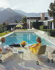 Gather around the poolside chic of Pieceworks Puzzle 1000 by Faire, where midcentury style, mountain views, and lush lawns set the scene as women relax and chat, with flowers and drinks adding charm to this stylish puzzle.