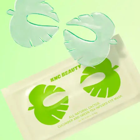 A green-tinted image features Faire's all-natural Cucumber/Tea Eye Mask, enriched with cactus and cucumber. The masks, shaped like large tropical leaves, rest elegantly above the packaging.