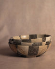 Round travertine checkered bowl by Faire, handcrafted centerpiece for modern living or dining rooms.
