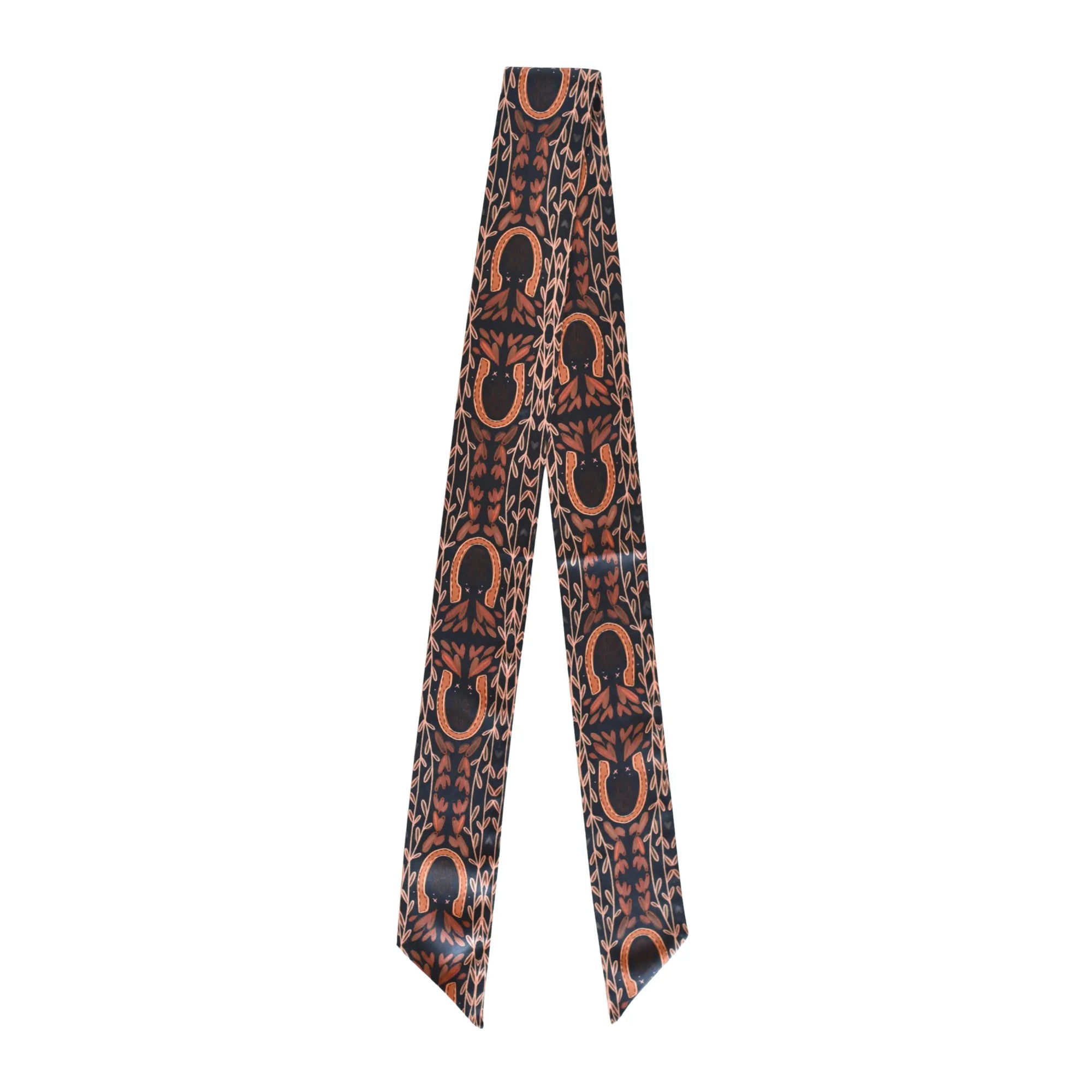 The Faire Western Harvest Twilly scarf features a narrow silk design with pointed ends and a hand-drawn pattern of brown horseshoes and abstract shapes on a dark background.