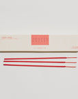 A box of Faire PFC Incense Sticks in "Smoked Cherry" sits on a white surface, capturing the rich Marasca cherry essence. Beside it, three red sticks lie horizontally, their sleek minimalist packaging embodying a chic HI-FI style with bold red text.