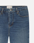 Close-up of FRAME's The Ruler Crop jeans in medium-blue denim, featuring front pockets, belt loops, button closure, and an inner waistband label—crafted in a slim-straight leg style.