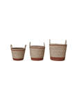 Three Seagrass Baskets with Brown Stripe & Handles by Creative Co-op, in different sizes, lined up and featuring brown and natural hues, each styled in a bungalow theme against a white background.