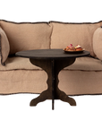 Maileg Coffee Table Miniature with pastries, cozy living room setting, beige loveseat in background.