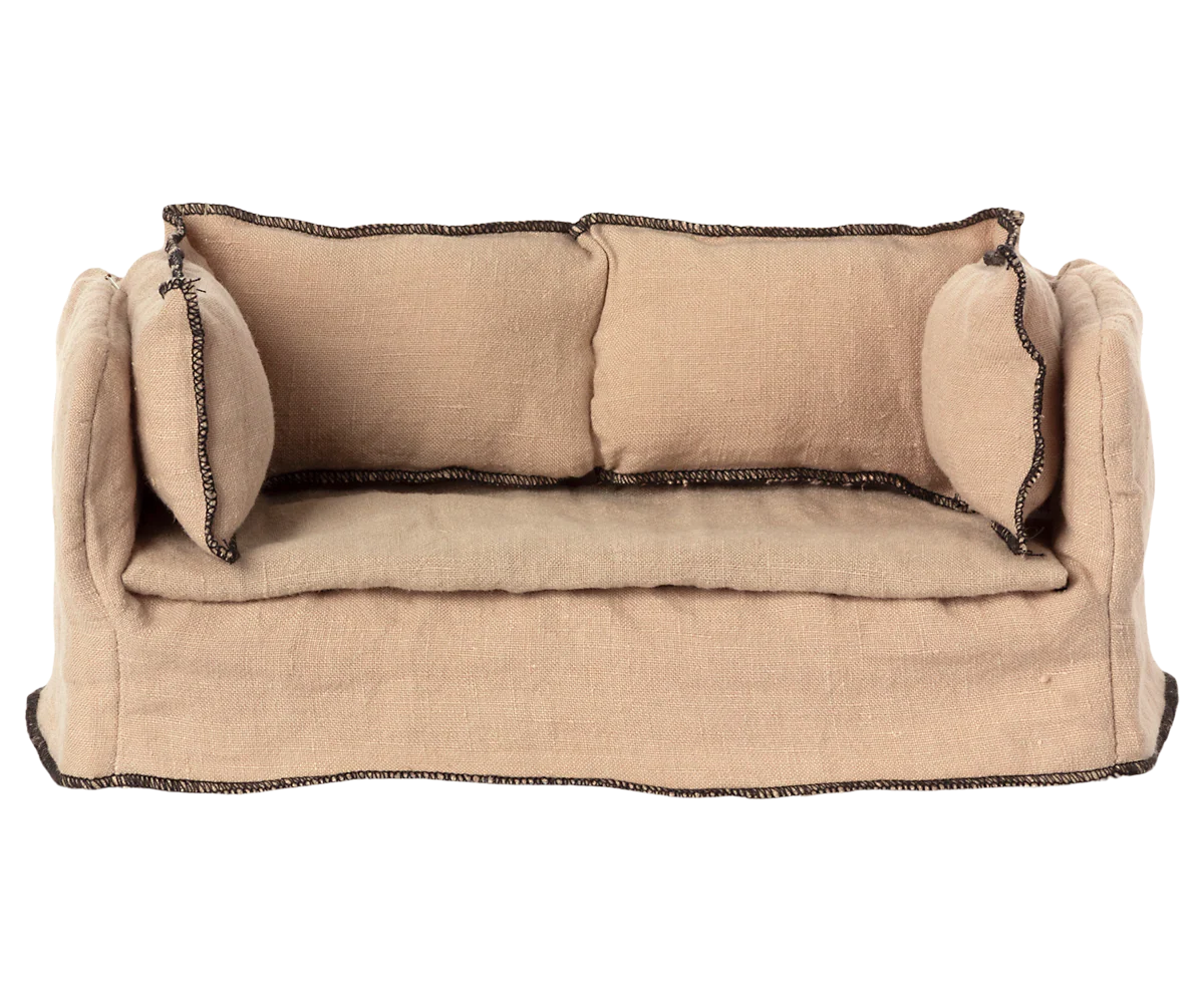 The Maileg Couch, Miniature by Maileg is a small beige sofa with two matching cushions and dark trim, shown from the front on a plain white background—ideal dollhouse furniture.