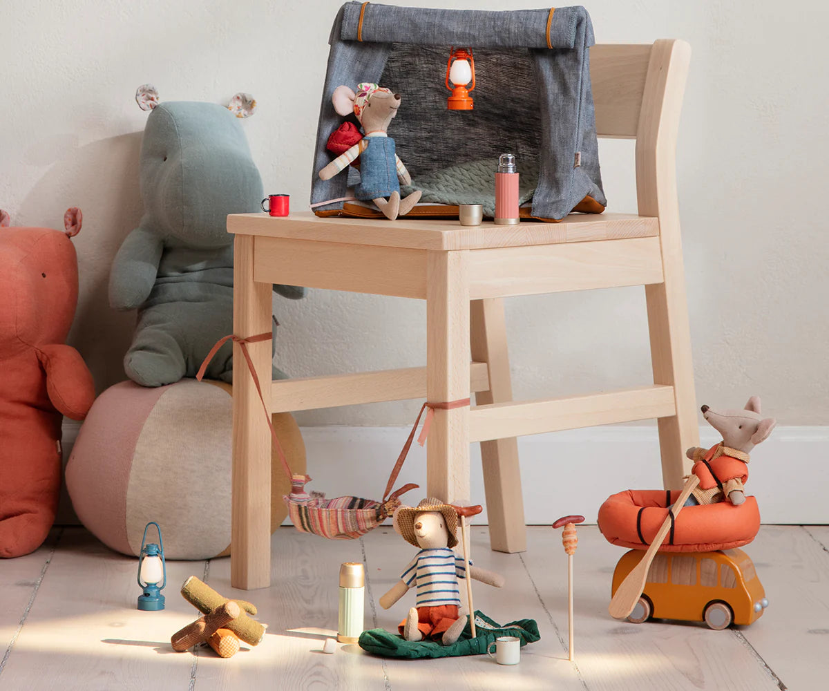 A whimsical camping scene: hiker mice relax in a tent, with Maileg Thermos & Cups by Maileg, lanterns, a bonfire, plush animals, and more on a light wooden floor.