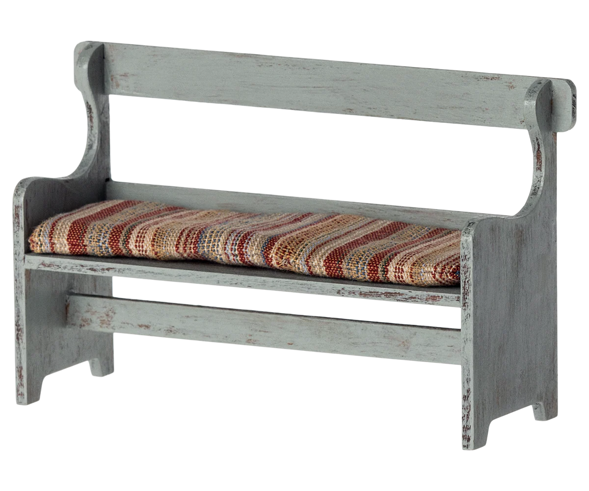 The Maileg Furniture bench by Maileg features a rustic wooden design with a distressed gray finish and striped, multicolored cushion—perfect for dollhouses or your Maileg Mouse collection.