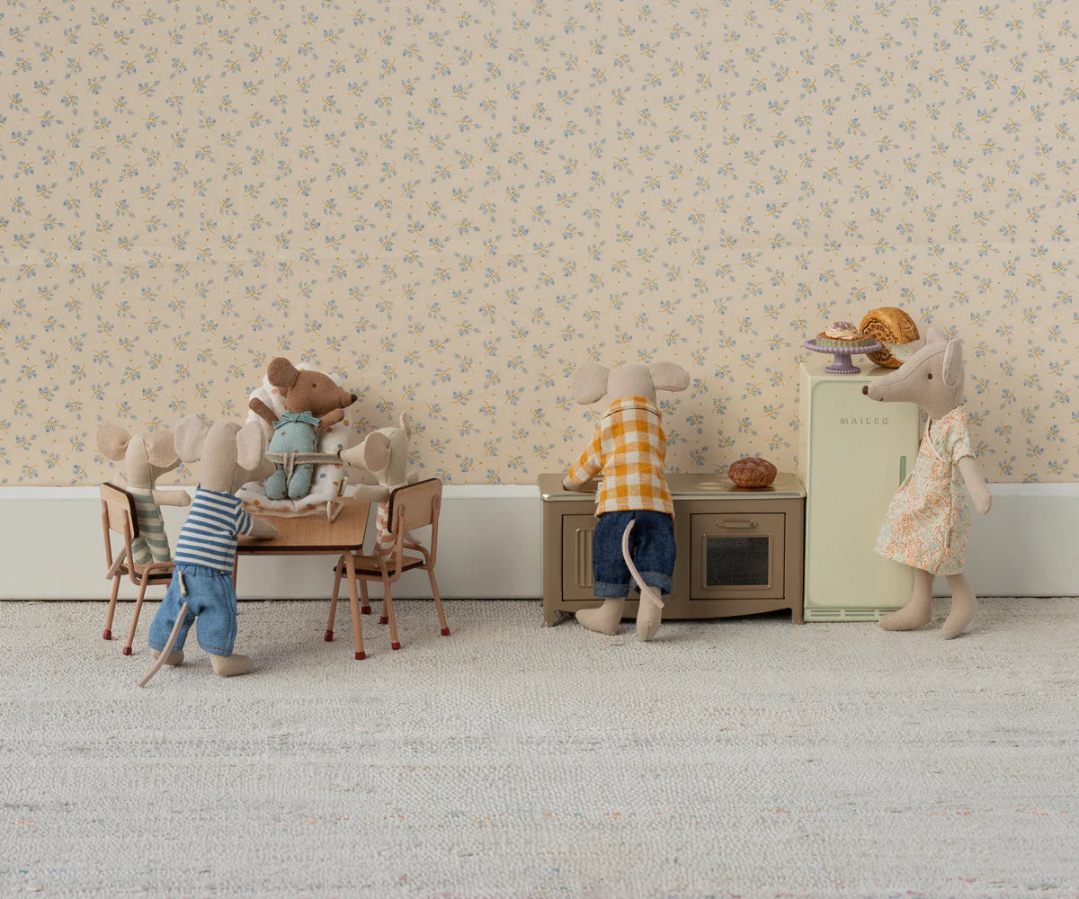 Five Maileg toy mice bring the Maileg Kitchen to life, with two at a table, one standing nearby, and two at the stove and fridge. The scene features floral wallpaper and a light carpet for added charm.