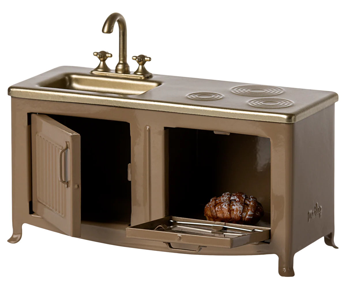 The Maileg Kitchen by Maileg is a miniature gold and bronze dollhouse set featuring a sink, stove burners, and two open oven compartments, one with a small cooked roast inside.