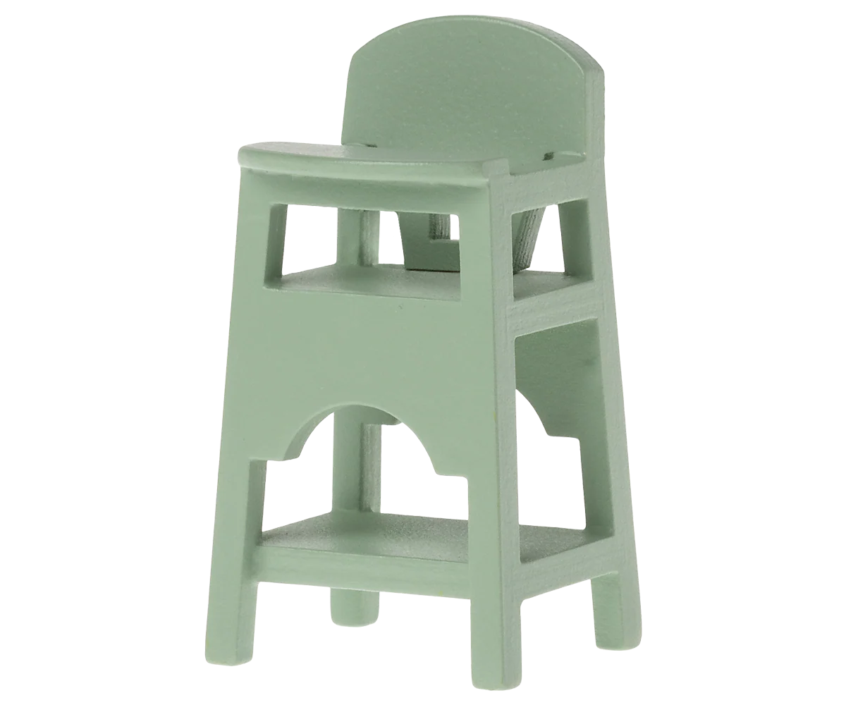 The Maileg High Chair by Maileg is a small, light green plastic chair with backrest and footrest, designed for dollhouse or baby mice play. It features a minimalist look and is photographed against a plain white background.