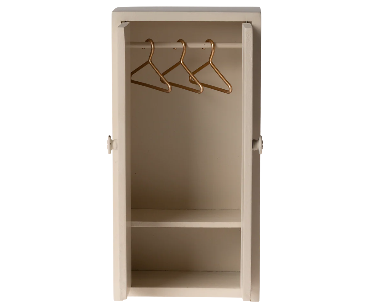 The Maileg Closet is a small, beige miniature wardrobe with its door open, featuring two shelves and three gold-colored metal hangers—perfect for mouse closets or tiny clothes storage.