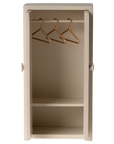 The Maileg Closet is a small, beige miniature wardrobe with its door open, featuring two shelves and three gold-colored metal hangers—perfect for mouse closets or tiny clothes storage.