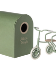 Green Maileg tricycle with matching shed, charming storage for mouse toys; perfect for playful kids’ rooms.