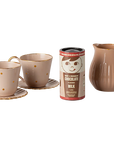 Mini hot chocolate set with two teacups, saucers, pitcher, and pretend cocoa by Maileg on white background.