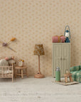 A miniature dollhouse room features a small bed, pillows, blanket, vintage alarm clock, lamp, green plaid armchair, tiny table with thermos and cup, cabinet with bags, and the Maileg Vintage Lantern by Maileg against floral wallpaper.