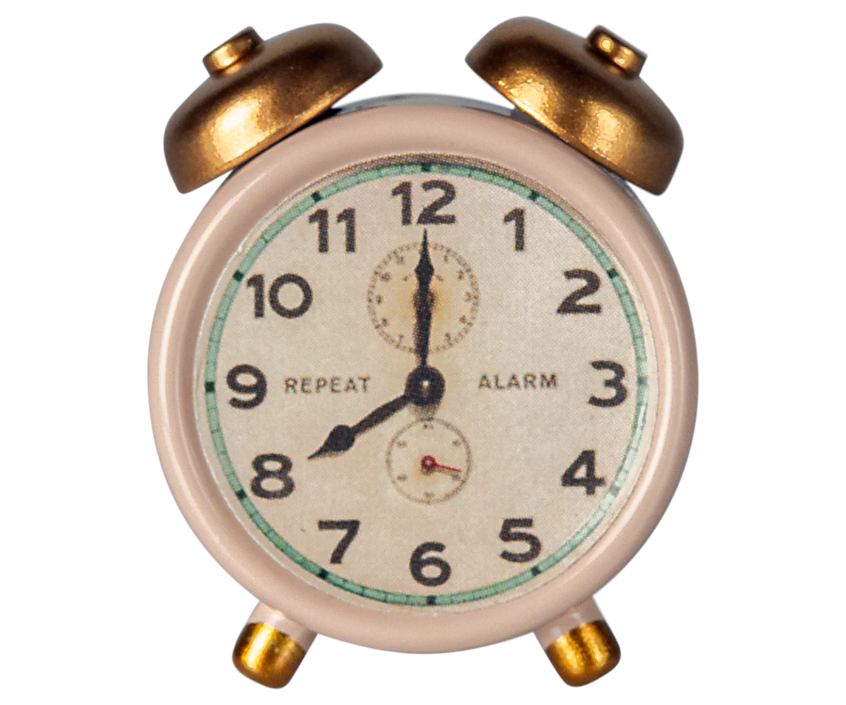 The Maileg Alarm Clock by Maileg is a small vintage-style metal clock with gold bells and legs, displaying 8:00. Its face shows black numbers, "REPEAT" and "ALARM," plus two extra dials above and below the center.