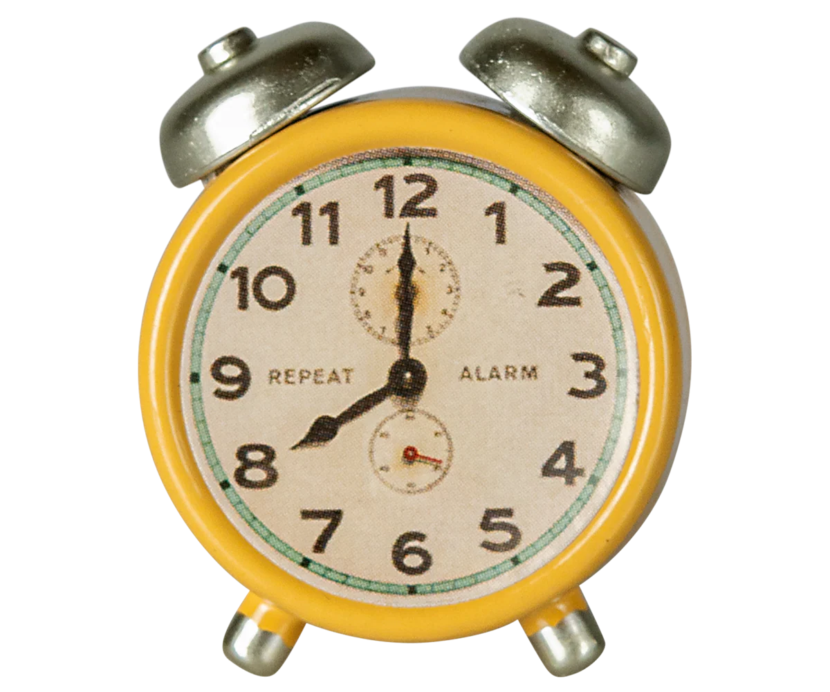 The Maileg Alarm Clock is a yellow vintage-style metal clock with black hands and numbers, displaying 8:00. "REPEAT" and "ALARM" are printed on the face, enhancing its classic twin-bell charm.