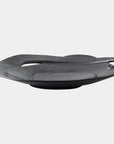 The Global Views Spiral Plate Black features a modern, sculptural ceramic design with black glaze, an irregular organic shape, slightly elevated base, and a small curved handle—strikingly displayed against a plain white background.