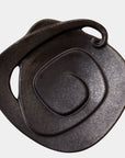 The Spiral Plate Black by Global Views features a black glaze, abstract spiral design, curved edge, and small looped handle, shown against a white background.