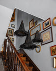 Faire light-up witch hats glowing over a staircase, creating a festive Halloween accent for Bungalow home décor.