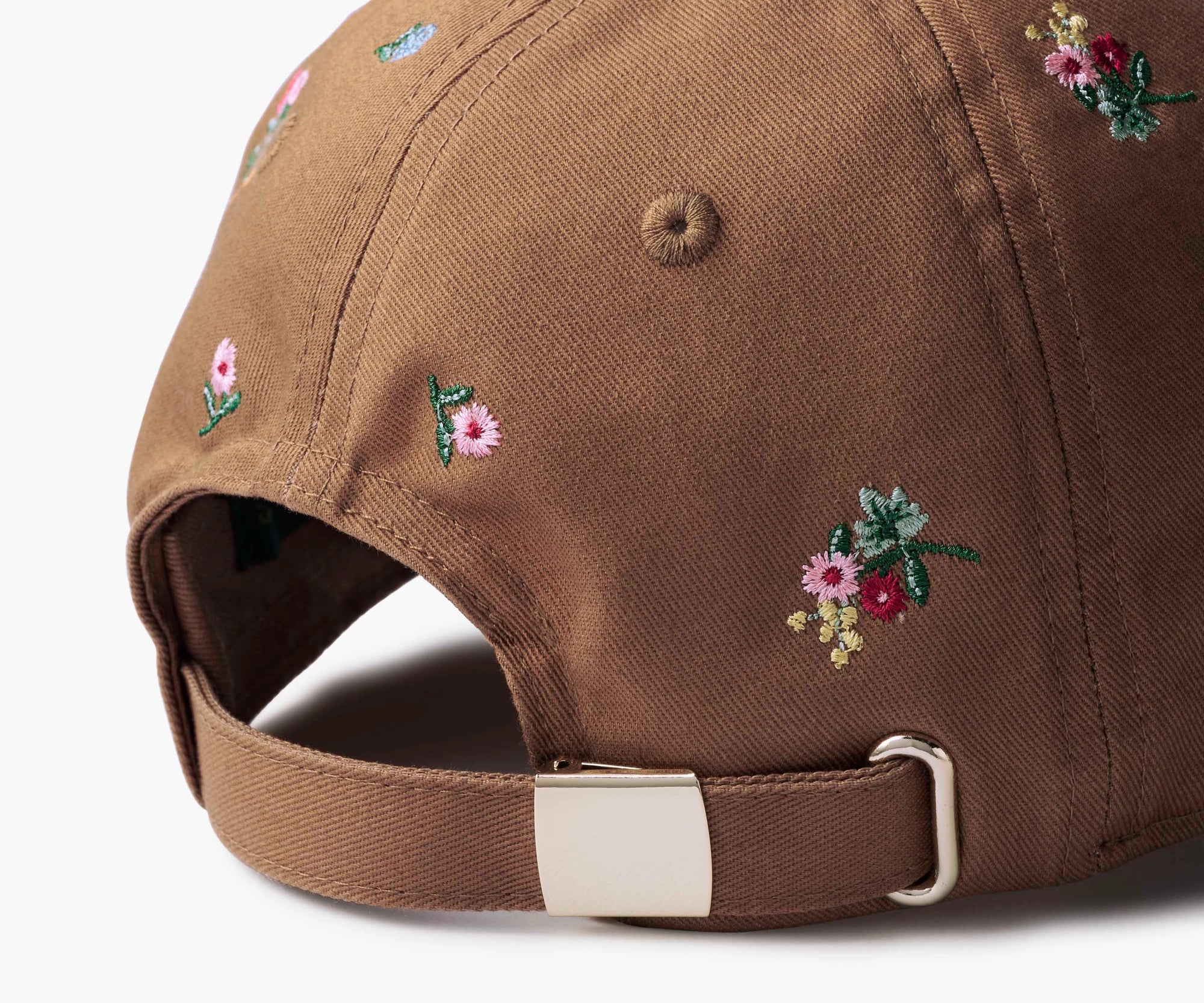 Close-up of the Faire Ditsy Dahlia Baseball Cap's back, featuring small colorful embroidered flowers and an adjustable strap with a silver buckle—ideal for a garden party.