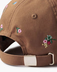 Close-up of the Faire Ditsy Dahlia Baseball Cap's back, featuring small colorful embroidered flowers and an adjustable strap with a silver buckle—ideal for a garden party.