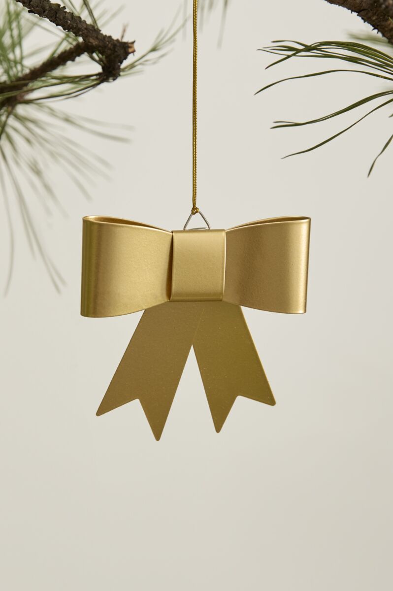 The Accent Decor Perfect Bow Ornament, featuring ribbon tails, hangs from a pine branch against a light background—adding an elegant touch to your holiday décor.